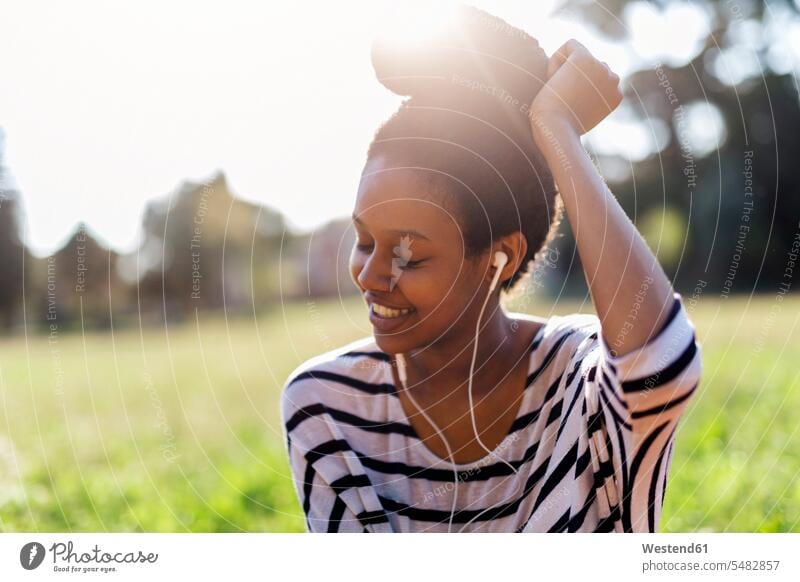 Lächelnde Frau hört Musik mit Kopfhörern Ohrhörer weiblich Frauen hören hoeren In-Ear Kopfhoerer Erwachsener erwachsen Mensch Menschen Leute People Personen