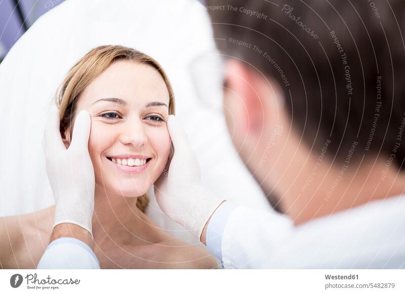 Ästhetische Chirurgie, Arzt schaut Frau an ansehen Patientin Kranke Patientinnen lächeln Schönheitschirurgie Schönheitsoperationen Schoenheitsoperation