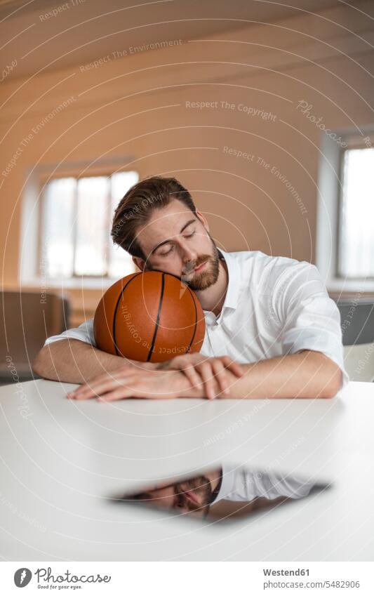 Porträt eines jungen Freiberuflers mit Basketball in der Pause freiberuflich freie Berufe Basketbaelle Basketbälle Sport sitzen sitzend sitzt ausruhen Rast