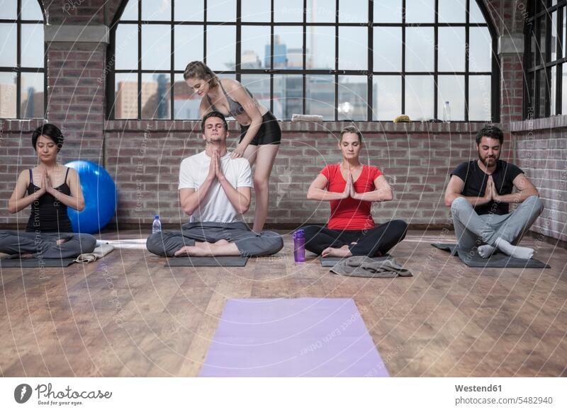 Frau unterrichtet Yogastunde Übung Uebung Übungen Uebungen sitzen sitzend sitzt Gruppe Gruppe von Menschen Menschengruppe Kurs Yoga-Übungen Yogauebungen
