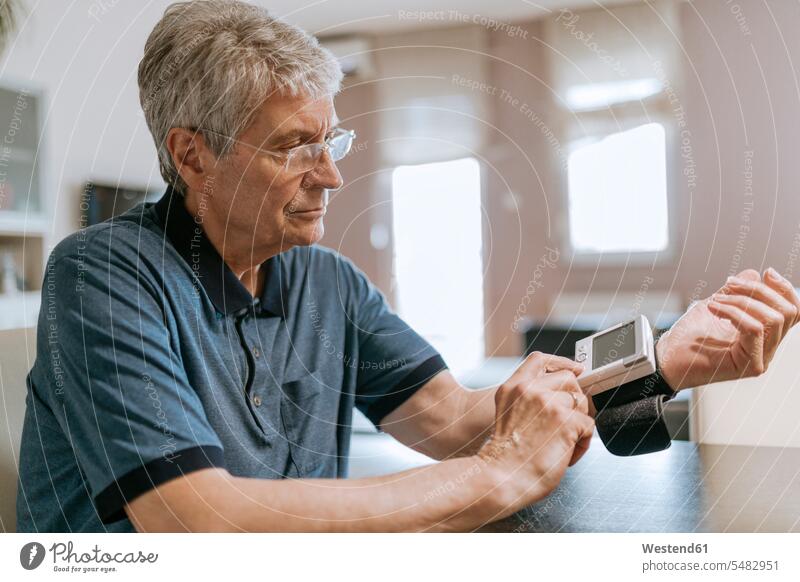 Älterer Mann misst seinen Blutdruck Senior ältere Männer älterer Mann Senioren prüfen Kontrolle Untersuchung kontrollieren pruefen männlich Erwachsener