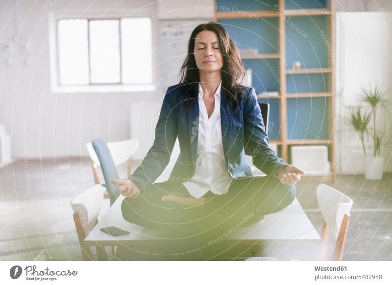 Geschäftsfrau macht Yoga-Übung am Schreibtisch in einem Loft Frau weiblich Frauen Erwachsener erwachsen Mensch Menschen Leute People Personen Yoga-Übungen