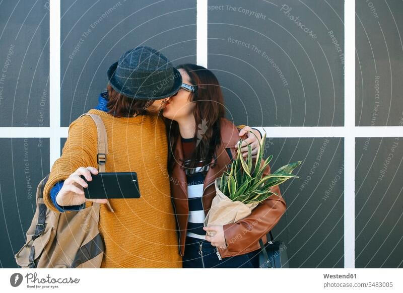 Küssendes junges Paar macht Selfie mit Smartphone Pärchen Paare Partnerschaft iPhone Smartphones Selfies küssen Kuss Mensch Menschen Leute People Personen Handy