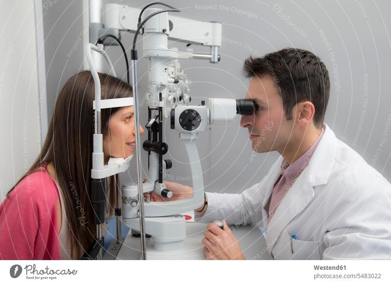 Frau beim Optiker, die einen Sehtest macht Test testen überprüfen ueberpruefen checken Kompetenz kompetent Optometrie Frau mittleren Alters
