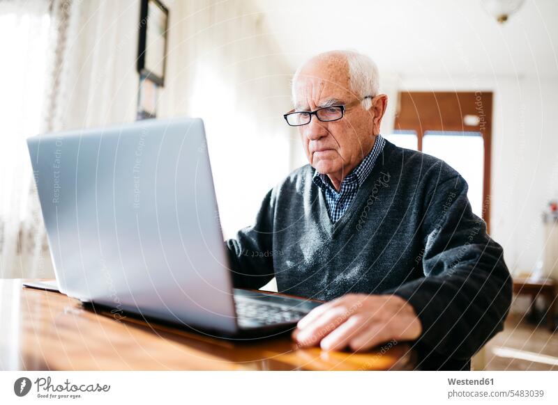Porträt eines seriös aussehenden älteren Mannes mit Laptop zu Hause Europäer Kaukasier Europäisch kaukasisch ernst Ernst Ernsthaftigkeit ernsthaft
