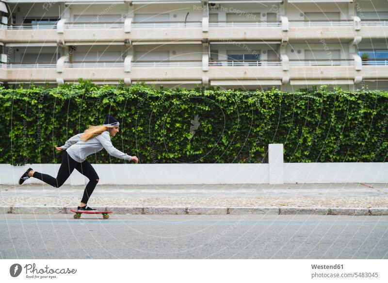 Junge Frau beim Skateboarden auf der Straße Skateboarderin Skateboardfahrerin Skaterin Skateboarderinnen Skaterinnen Skateboardfahrerinnen skateboarden weiblich