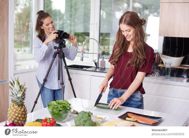 Frauen nehmen Video für ihren Food-Blog auf Fotokamera Kamera Kameras Leute Menschen People Person Personen erwachsen Erwachsene weiblich Küchen Essen