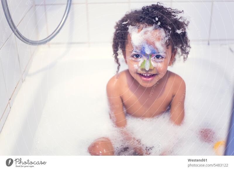 Porträt eines lächelnden kleinen Mädchens mit gemaltem Gesicht, das in einer Badewanne sitzt weiblich baden Kind Kinder Kids Mensch Menschen Leute People