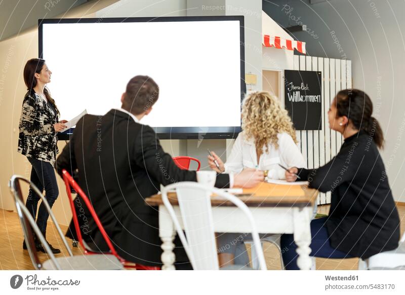 Frau leitet Präsentation im Büro auf großer Leinwand Geschäftsleute Bildschirm Workshop Geschäftsfrau Schulung Business Veranstaltung Arbeitsplatz Agentur