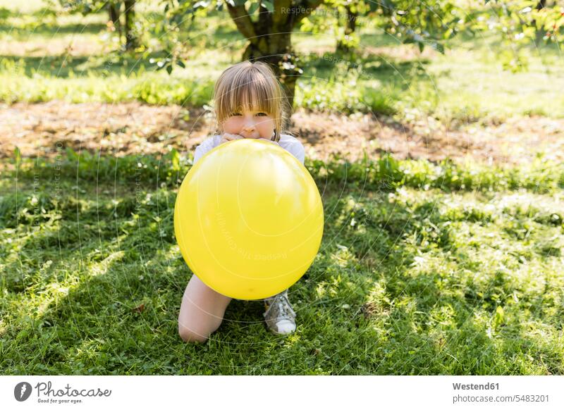 Mädchen bläst Ballon auf der Wiese weiblich Garten Gärten Gaerten aufblasen Luftballon Luftballons Ballons Luftballone Wiesen Kind Kinder Kids Mensch Menschen