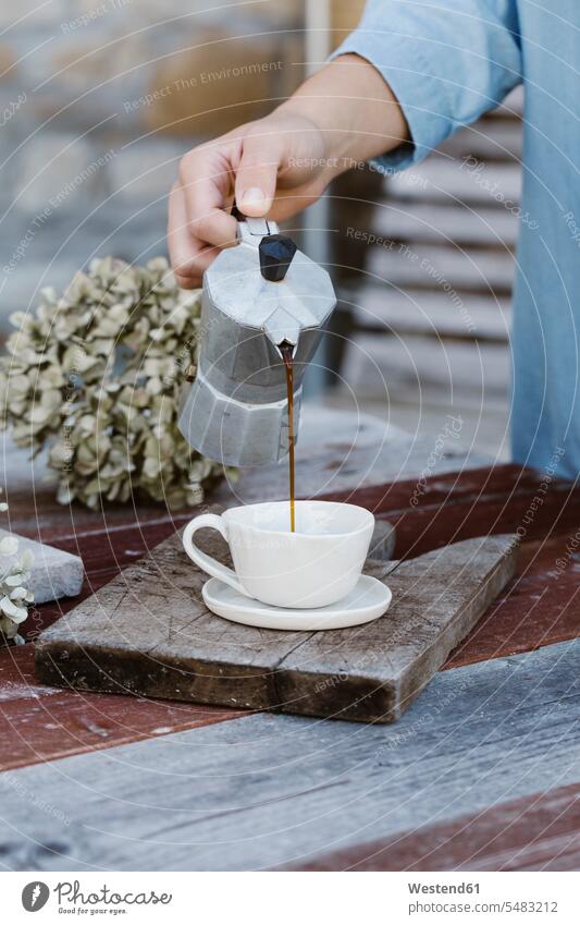 Italien, Frau gießt Espresso in Tasse auf Frühstückstisch, Teilansicht Hand Hände Tisch Tische Kaffee Terrasse Terrassen zubereiten kochen Essen zubereiten