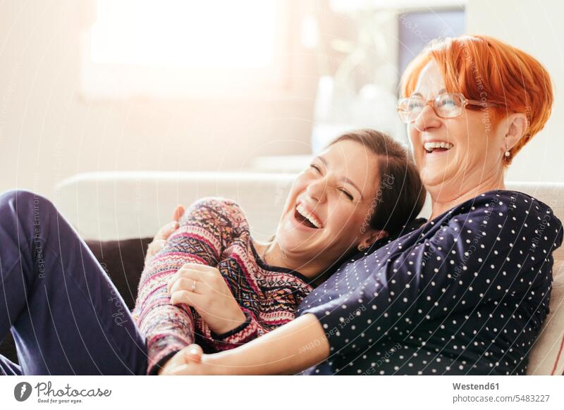 Glückliche erwachsene Tochter mit Mutter zu Hause Mami Mutti Mütter Mama lachen glücklich glücklich sein glücklichsein Töchter Frau weiblich Frauen Eltern
