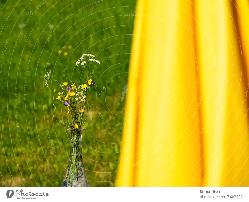 Wildblumenstrauß neben einem gelben Sonnenschirm, im Hintergrund eine Wiese Blumenstrauß Dekoration & Verzierung Sommer Natur optimistisch Alpen Alm Almhütte