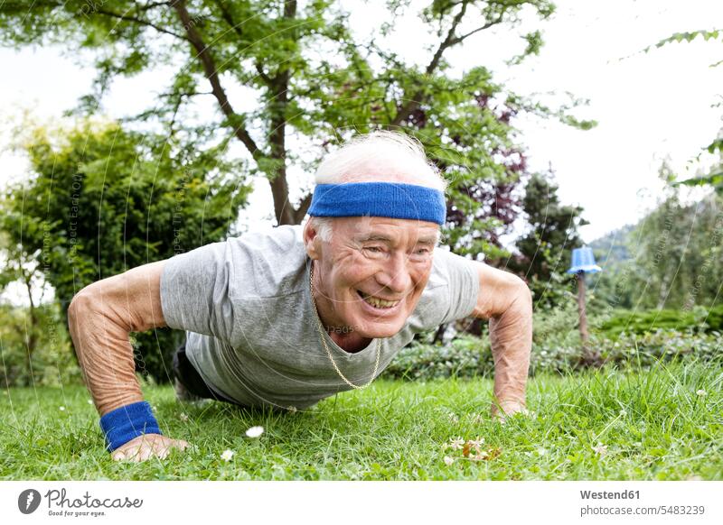 Älterer Mann macht Liegestütze für Fitnesstraining im Garten fit Senior ältere Männer älterer Mann Senioren Liegestützen Push-Up Pushups Push-Ups Gärten Gaerten