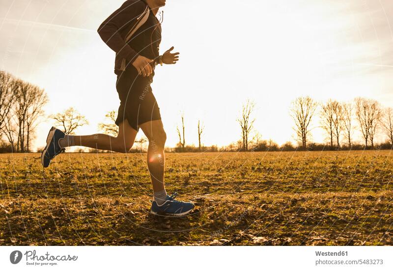Mann läuft in ländlicher Landschaft laufen rennen Männer männlich Joggen Jogging Erwachsener erwachsen Mensch Menschen Leute People Personen Fitness fit