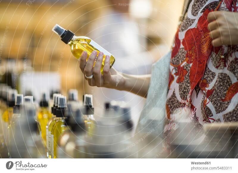 Nahaufnahme einer Frau mit einer Parfümflasche im Geschäft halten weiblich Frauen Flasche Flaschen Parfum Flakons Parfumflasche Shop Laden Läden Geschäfte Shops