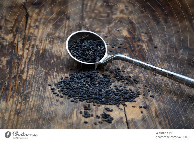 Masse von organischem schwarzem Sesam auf dunklem Holz schwarzer schwarzen schwarzes Körner Korn Sesamsamen Sesamsaat Bio Biologische Lebensmittel
