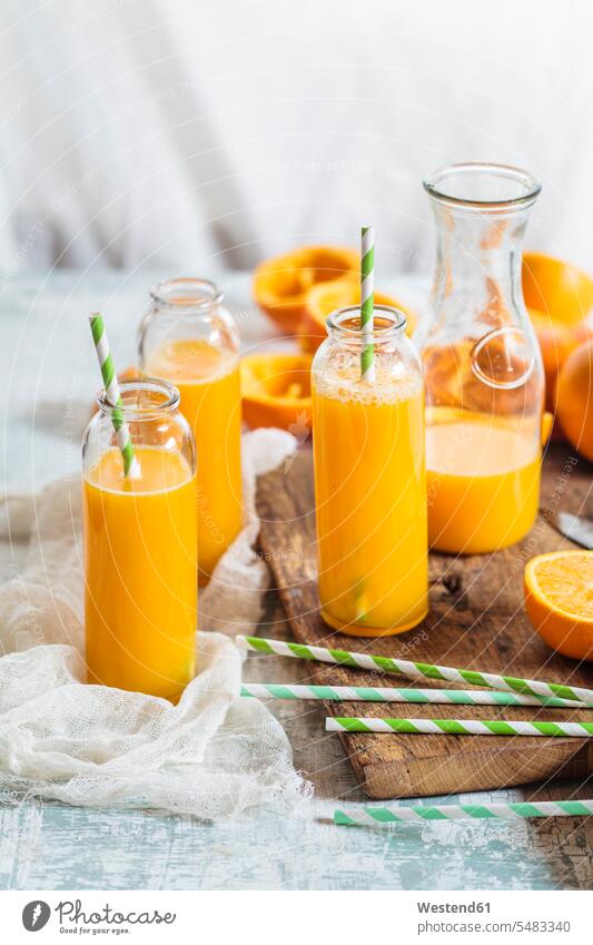 In Scheiben geschnittene Orangen und Glasflaschen mit frisch gepresstem Orangensaft Food and Drink Lebensmittel Essen und Trinken Nahrungsmittel Trinkgläser