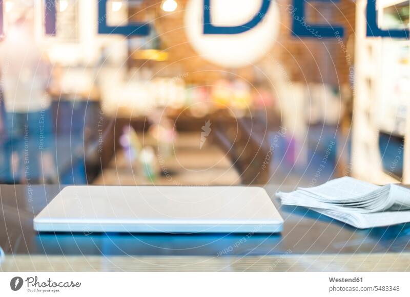 Laptop und Zeitung auf dem Tisch in einem Cafe Mobilität mobil mobiles Arbeiten mobile working Deutschland Nahaufnahme Nahaufnahmen Großaufnahme close up