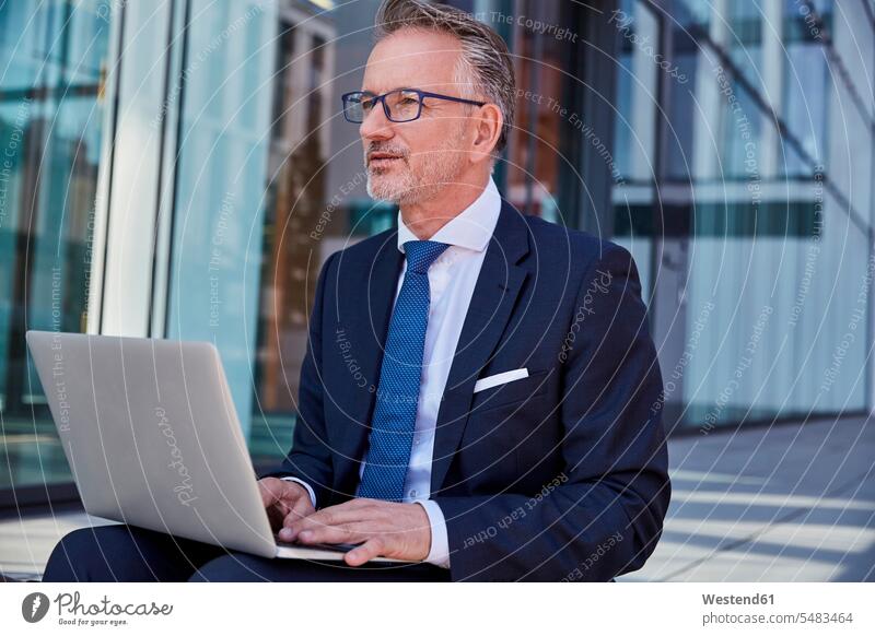 Porträt eines Geschäftsmannes mit Laptop im Freien Notebook Laptops Notebooks Businessmann Businessmänner Geschäftsmänner Computer Rechner Geschäftsleute