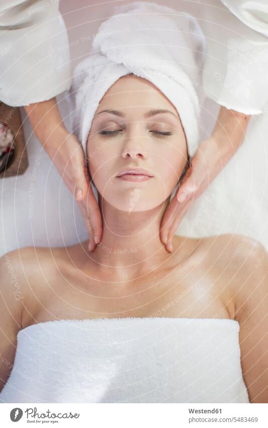 Junge Frau liegt auf Massagetisch und erhält Schönheitsbehandlung weiblich Frauen entspannt entspanntheit relaxt Massagen massieren Wellness Gesundheit liegen