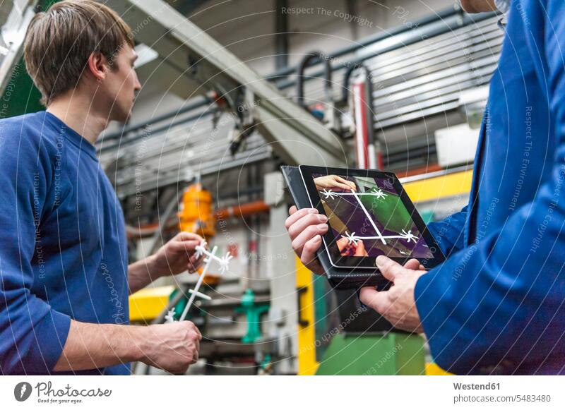 Manager und Arbeiter untersuchen Produkte in der Plastcs-Fabrik Kunststoff Plastik Bauteil Bauteile Drahtlose Technologie drahtlose Verbindung