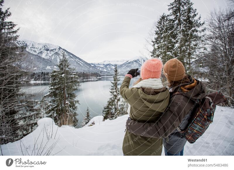 Ehepaar beim Fotografieren in alpiner Winterlandschaft mit See winterlich Winterzeit Seen fotografieren Landschaft Landschaften Paar Pärchen Paare Partnerschaft