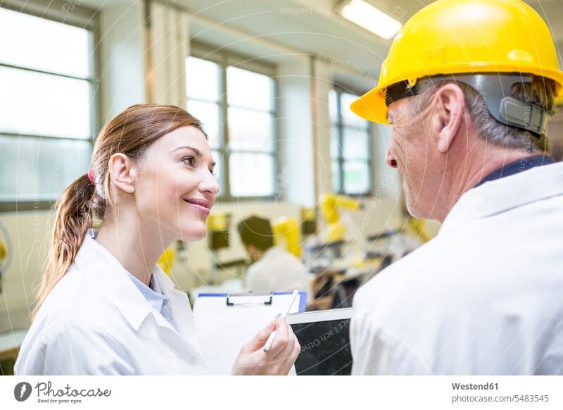Zwei lächelnde Ingenieure in der Fabrik sprechen reden Fabriken Kollegen Arbeitskollegen Technik Techniken Technologie Industrie industriell Gewerbe Industrien