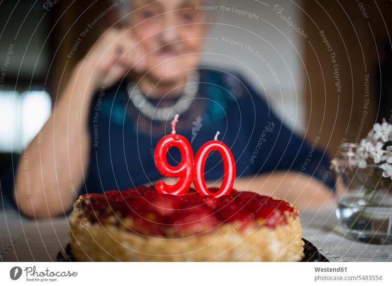 Kerzen auf dem Geburtstagskuchen einer älteren Frau, die ihren neunzigsten Geburtstag feiert Tisch Tische Lebensabend 90 Lebensereignisse besondere Ereignisse