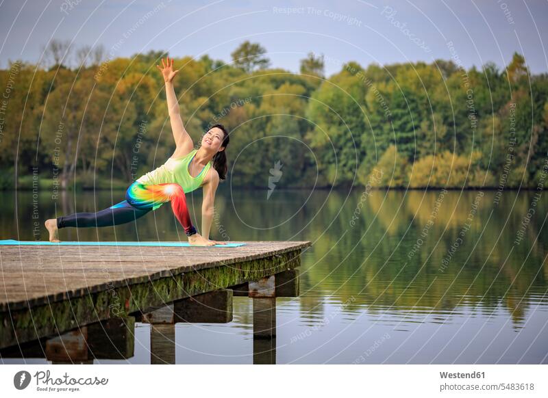 Frau praktiziert Yoga auf einem Steg an einem See Seen Übung Uebung Übungen Uebungen Stege Anlegestelle weiblich Frauen Gewässer Wasser Erwachsener erwachsen