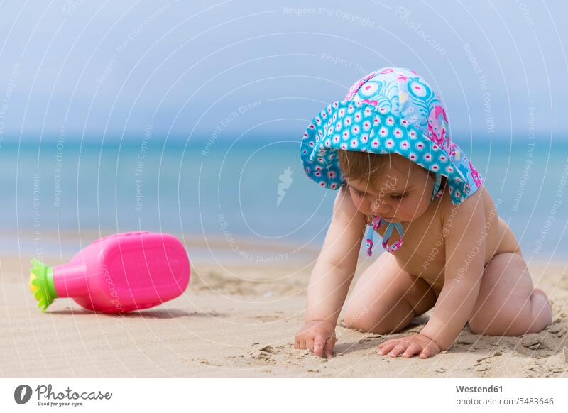Kleines Mädchen mit Sommermütze beim Spielen am Strand modisch eine Person single 1 ein Mensch einzelne Person Ein nur eine Person betrachten betrachtend