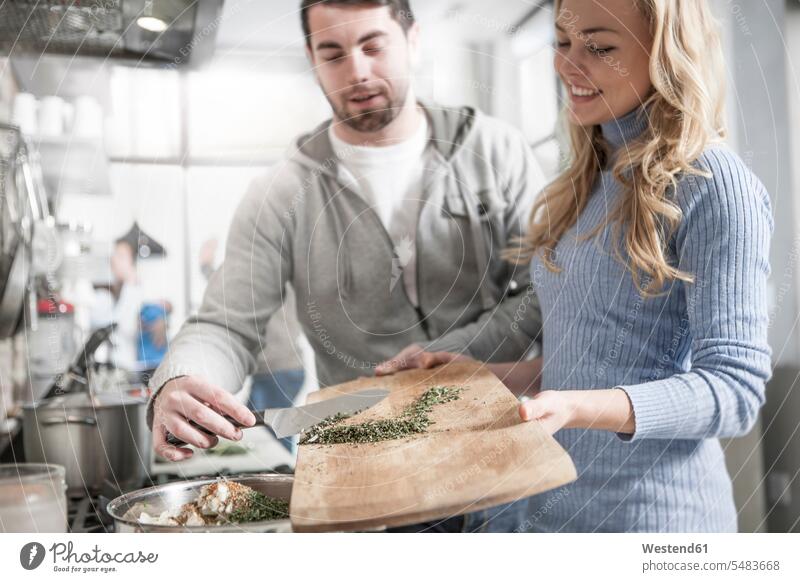 Paare helfen sich gegenseitig beim Bewegen von Gewürzen im Topf Küche Küchen kochen Pärchen Partnerschaft Mensch Menschen Leute People Personen Freunde