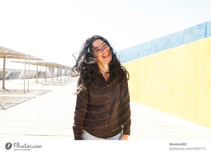 Porträt einer glücklichen Frau im Freien Europäer Kaukasier Europäisch kaukasisch Freude freuen schwarzhaarig schwarzhaariges schwarzes Haar schwarze Haare