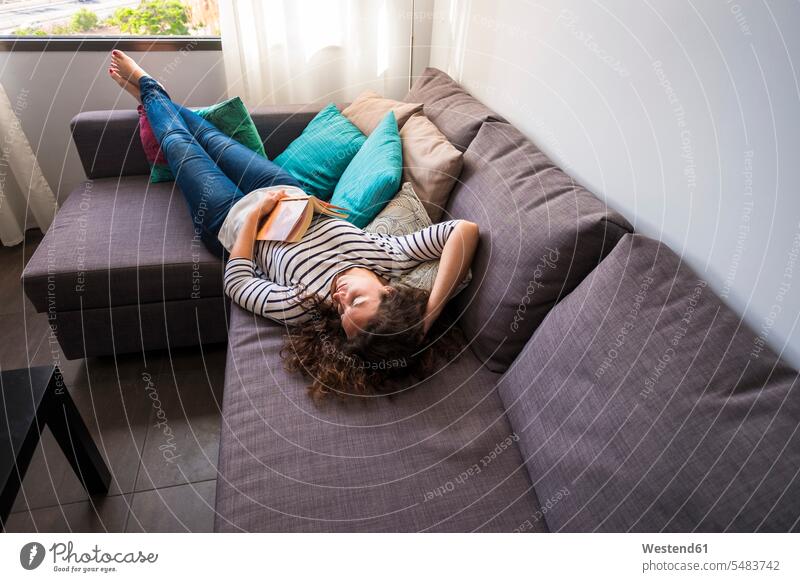 Frau entspannt sich auf der Couch Sofa Couches Liege Sofas liegen liegend liegt weiblich Frauen Erwachsener erwachsen Mensch Menschen Leute People Personen Buch