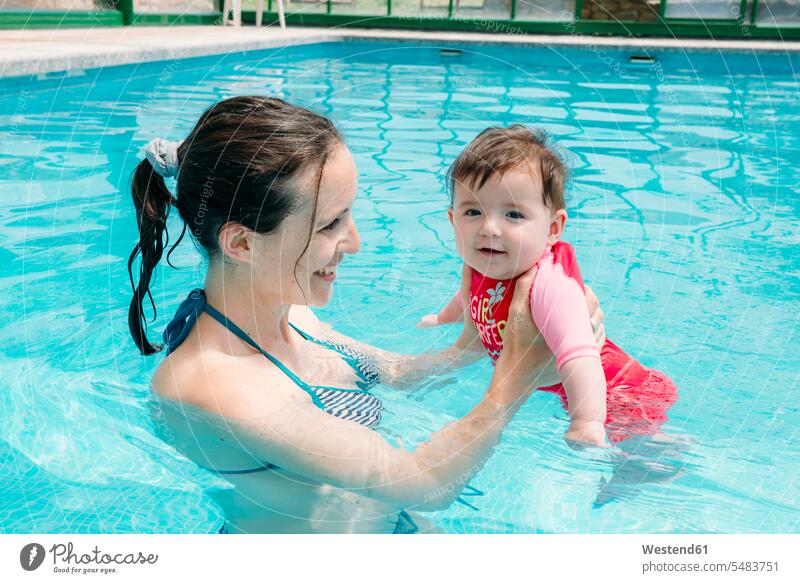 Süßes Mädchen, das lernt, mit seiner Mutter im Schwimmbad zu schwimmen lächeln Baby Babies Babys Säuglinge Kind Kinder Mami Mutti Mütter Mama Swimmingpool