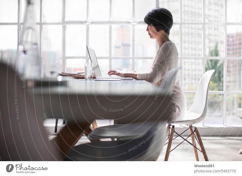 Frau hinter einem modernen Schreibtisch im Stadtbüro Drahtlose Technologie drahtlose Verbindung Drahtlose Kommunikation schnurlose Verbindung Chinesin