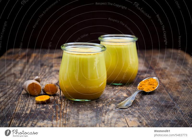 Zwei Gläser Kurkuma-Milch Glas Gesunde Ernährung Ernaehrung Gesunde Ernaehrung Gesundheit gesund Lifestyle Lebensstil hölzern rustikal Gelbwurz Turmerik