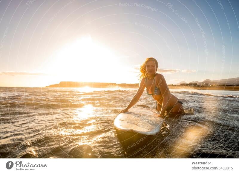 Spanien, Teneriffa, junge Surferin bei Sonnenuntergang Sonnenuntergänge Surfen Surfing Wellenreiten Frau weiblich Frauen Wellenreiterinnen Surferinnen Abend