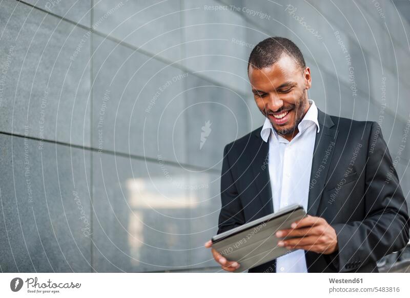 Lächelnder Geschäftsmann mit Tablette lächeln Tablet Computer Tablet-PC Tablet PC iPad Tablet-Computer Businessmann Businessmänner Geschäftsmänner Rechner