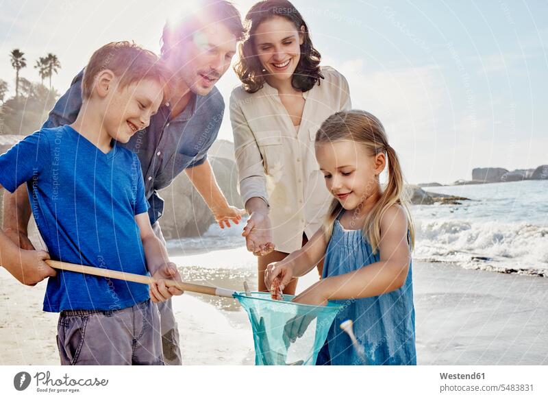 Glückliche Familie mit Sprungtuch am Strand Kescher Beach Straende Strände Beaches Familien glücklich glücklich sein glücklichsein lächeln Fanggerät Fanggeräte