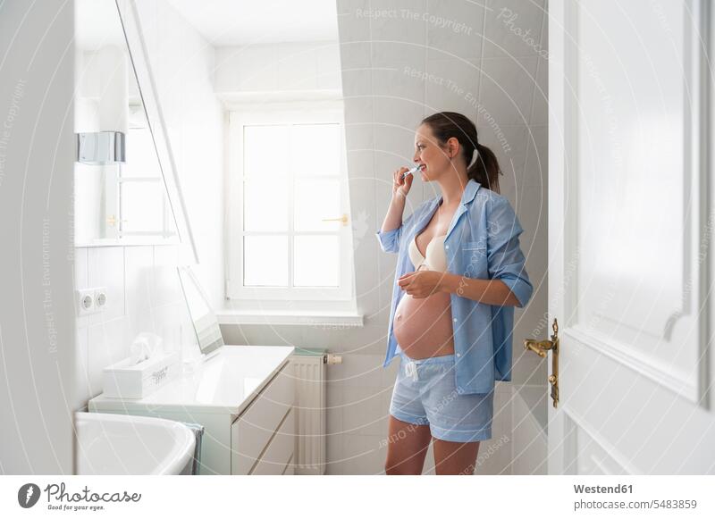 Schwangere Frau im Badezimmer beim Zähneputzen weiblich Frauen Zähne putzen Zaehne putzen schwanger schwangere Frau Erwachsener erwachsen Mensch Menschen Leute