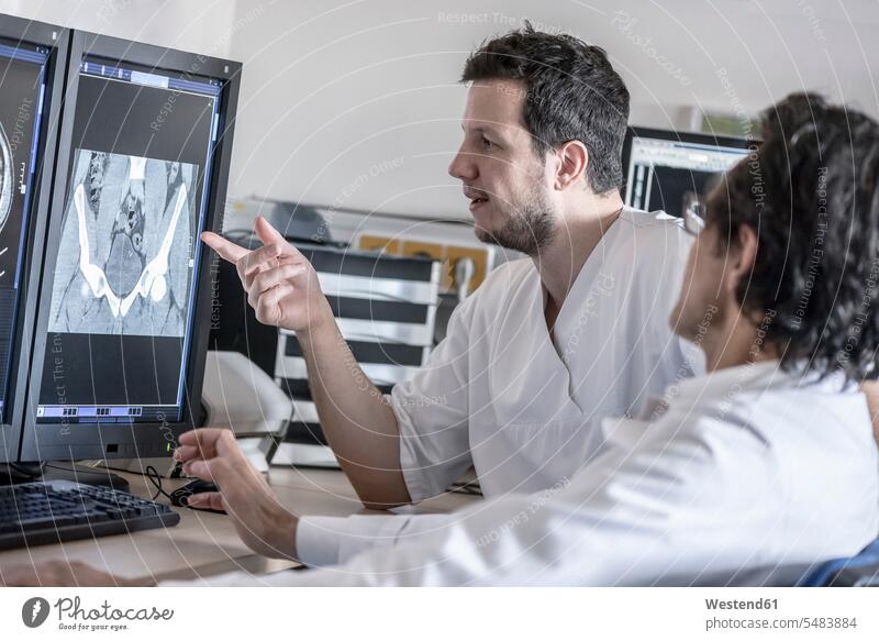 Zwei Ärzte besprechen Röntgenbild am Computerbildschirm Roentgenbild Roentgenbilder Röntgenaufnahmen Roentgenaufnahmen Röntgenbilder Kollegen Arbeitskollegen