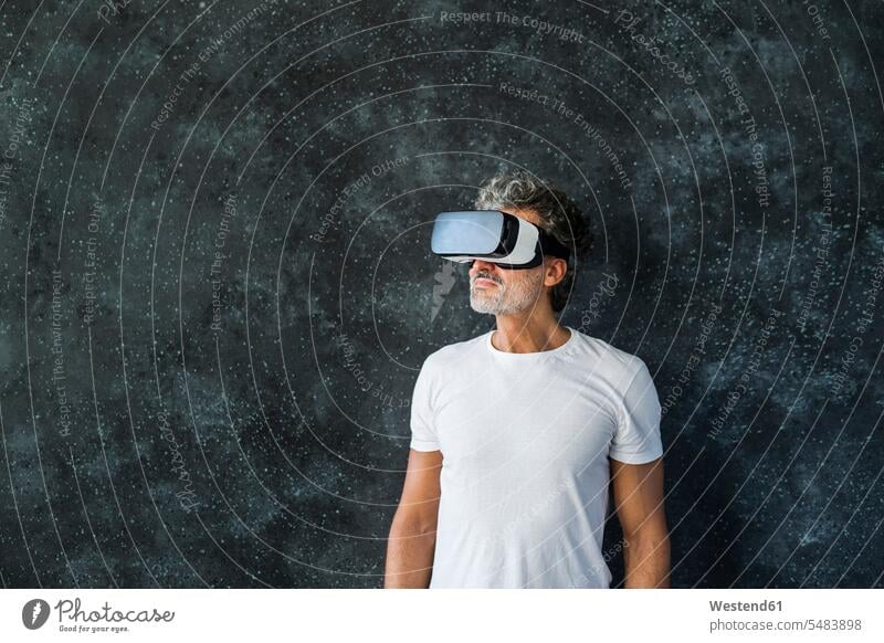 Reifer Mann schaut durch eine VR-Brille hindurchsehen Virtual Reality Brille Virtual-Reality-Brille Virtual Reality-Brille VR Brille ansehen betrachten