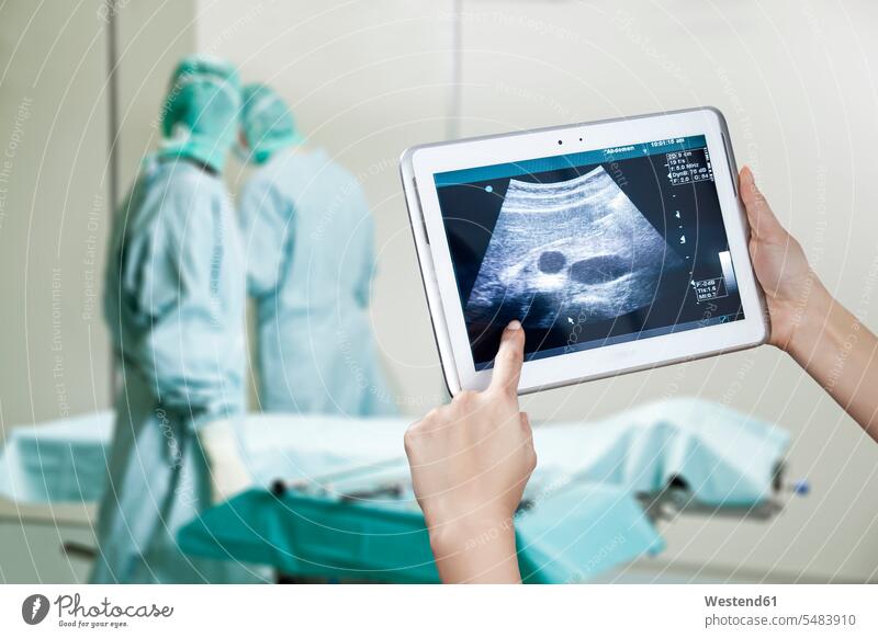 Hände halten digitales Tablett mit Ultraschallbild im Operationssaal Tablet Computer Tablet-PC Tablet PC iPad Tablet-Computer Fötus Foetus Ulgtraschall