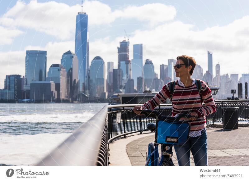 USA, Frau mit Fahrrad am Hafen von New Jersey mit Blick auf Manhattan New York New York State weiblich Frauen Bikes Fahrräder Räder Rad United States of America