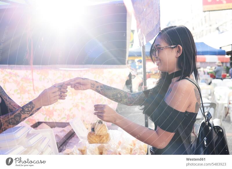 Lächelnde Frau kauft eine Ananas-Tasche bei einem Straßenhändler lächeln Tüte Tüten Tuete Tueten weiblich Frauen Straßenverkäufer Ananas comosus Ananas sativus