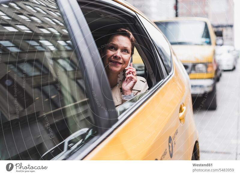 USA, New York City, lächelnde Frau im Taxi am Mobiltelefon Handy Handies Handys Mobiltelefone weiblich Frauen Taxis Taxen telefonieren anrufen Anruf