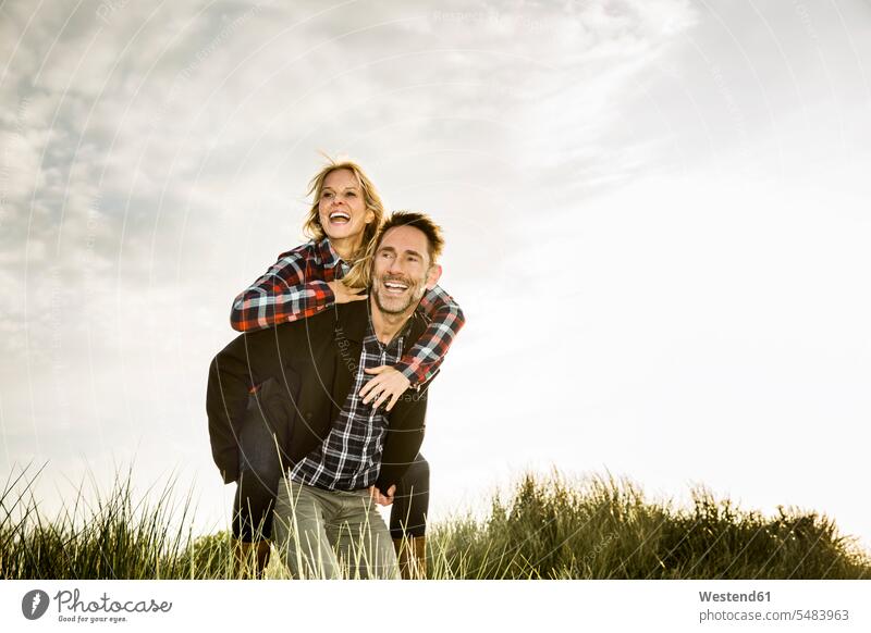 Glückliches verspieltes Paar in den Dünen lachen Pärchen Paare Partnerschaft Sanddüne Sanddünen positiv Emotion Gefühl Empfindung Emotionen Gefühle fühlen