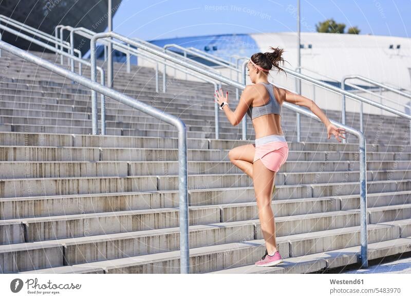 Fitte junge Frau, die auf einer Treppe läuft fit Treppenaufgang trainieren laufen rennen weiblich Frauen Erwachsener erwachsen Mensch Menschen Leute People