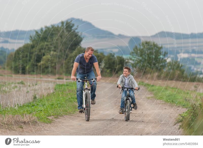Deutschland, Rheinland-Pfalz, kleiner Junge auf Fahrradtour mit seinem Vater Europäer Kaukasier Europäisch kaukasisch Tag am Tag Tageslichtaufnahme tagsueber